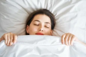 woman asleep in bed with covers